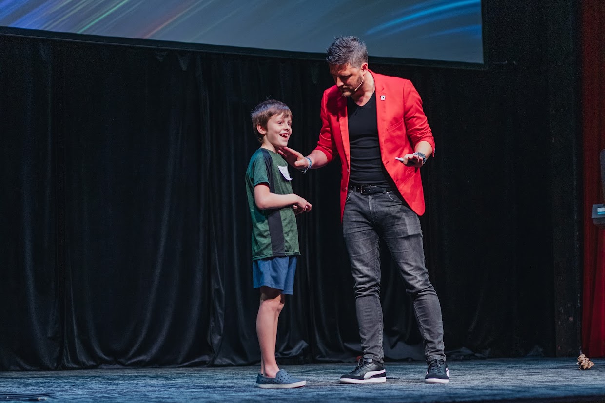Milan performing with a student on stage