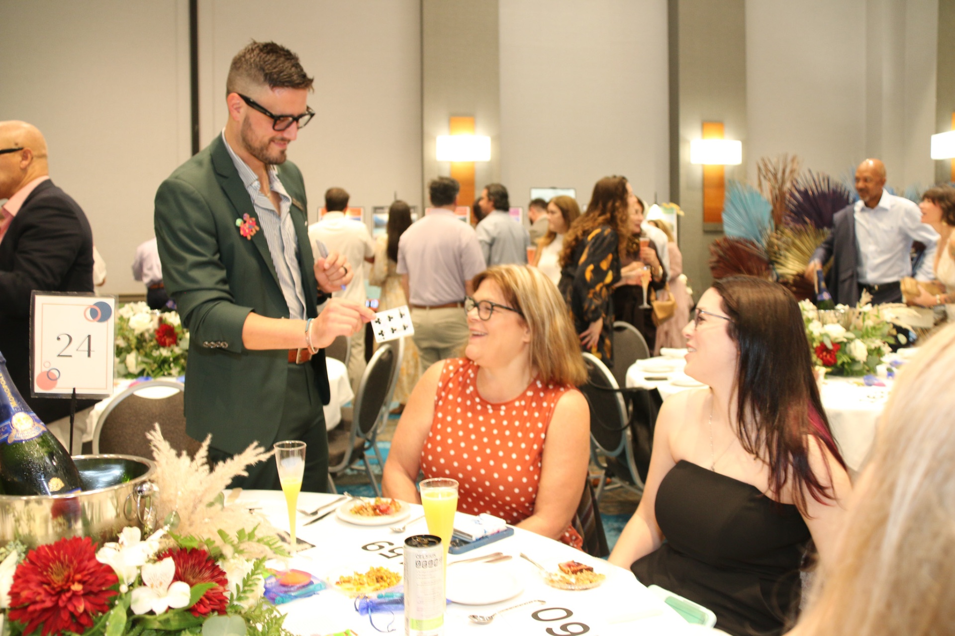 Milan performing table-side card magic at a banquet